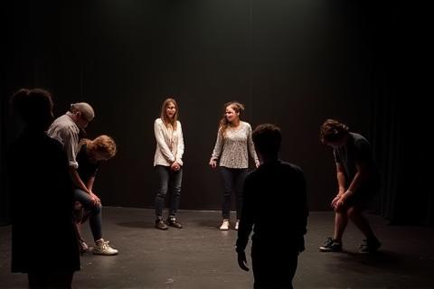 Students rehearsing a scene together on a simple stage setup, showing collaboration and focus