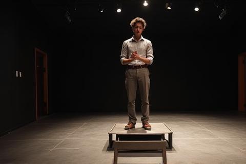 Student practicing lines on a small elevated stage area, showing focused individual practice